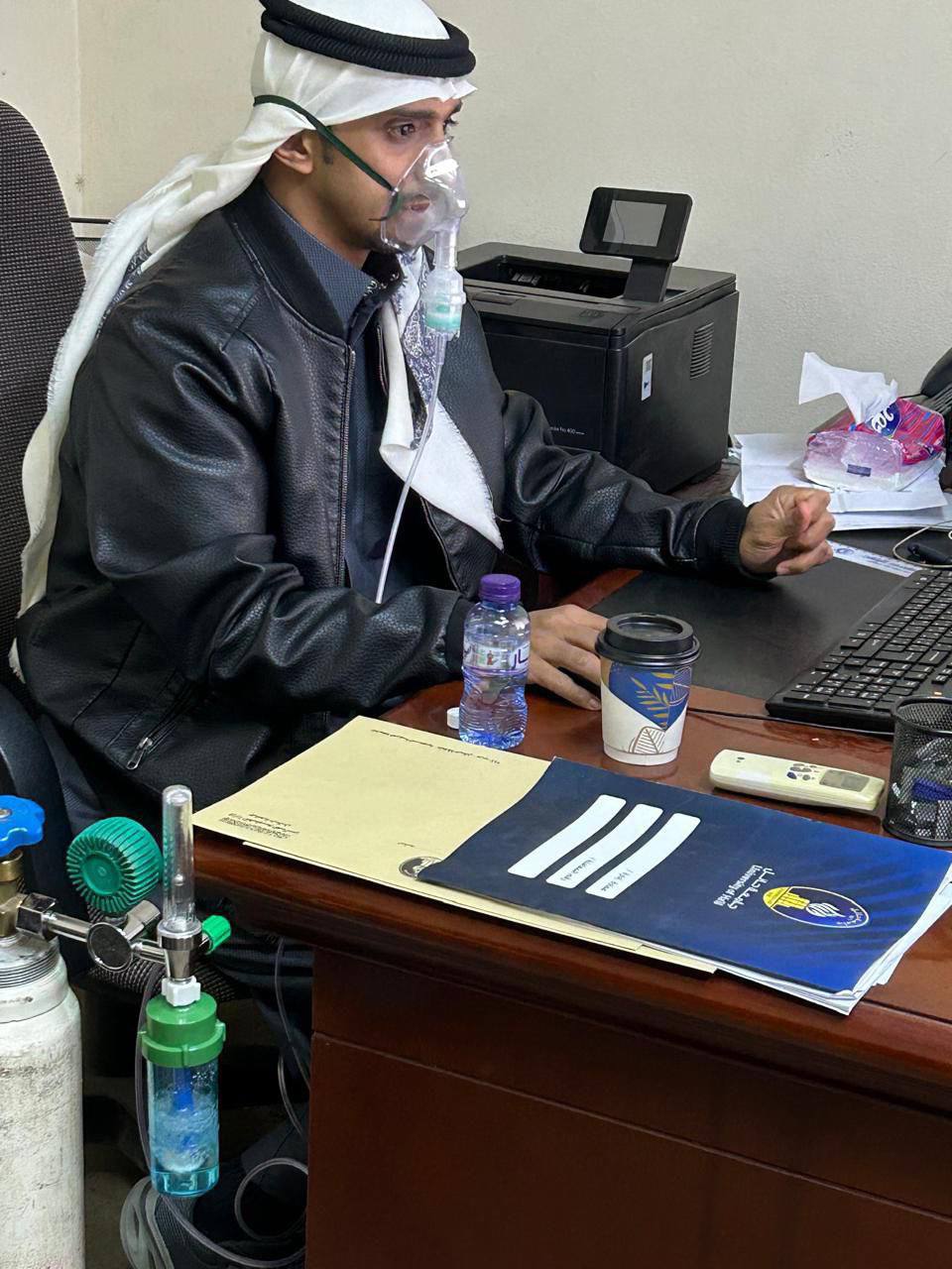 موظف سعودي يمارس عمله واضعا جهاز بخار متصل بأسطوانة أكسجين 